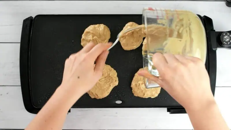 Protein pancake batter being added to a griddle.