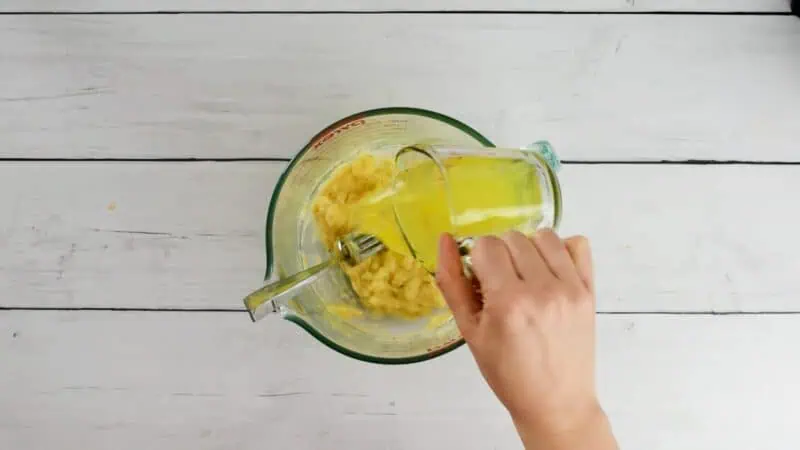 Egg whites being added to bowl with bananas.