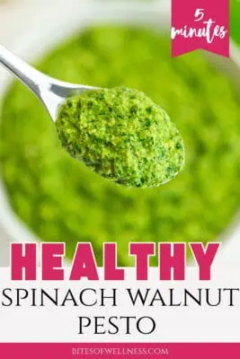 Bowl filled with spinach basil walnut pesto, spoon in the bowl.