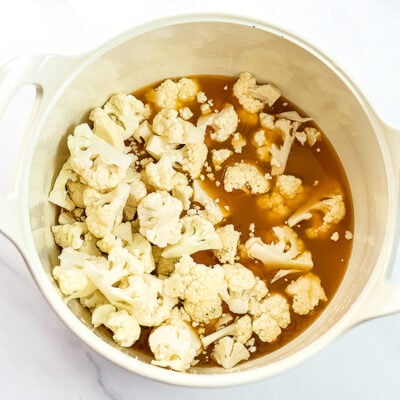 Cauliflower florets in a pot with vegetable broth.