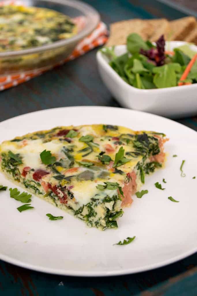 Slice of smoked salmon frittata on a white plate. 