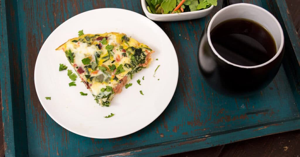 Sliced of egg white frittata with smoked salmon on a white plate. 