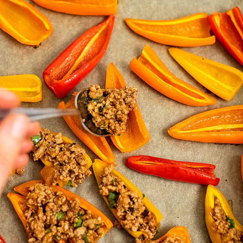Filling the bell pepper nachos with the ground turkey mixture.