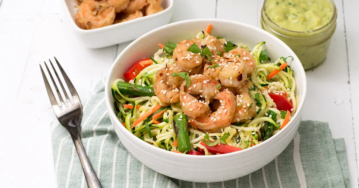 ginger garlic shrimp zoodle bowl with avocado cilantro dressing