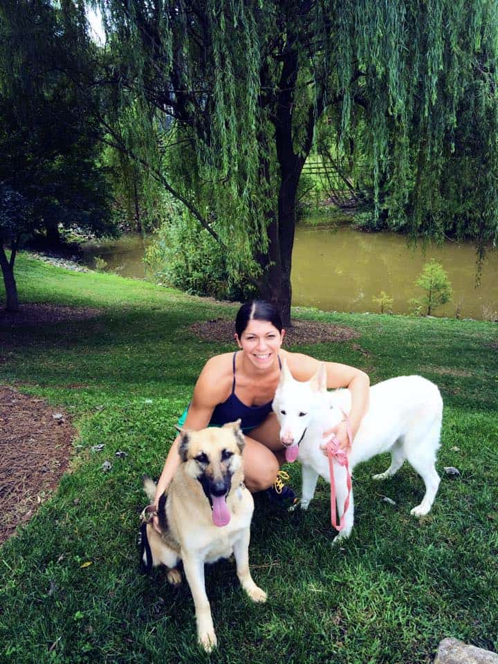Girl with two dogs, one tan and one white.