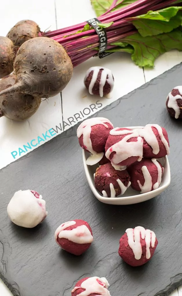 Red velvet protein bites drizzled with coconut butter piled in a bowl