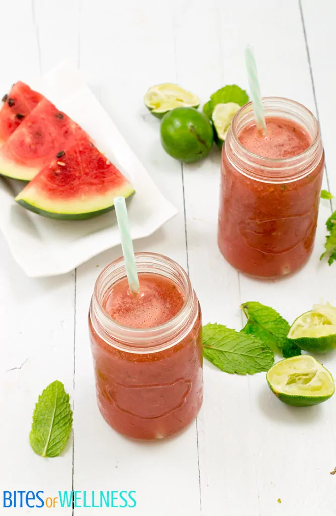 refreshing watermelon mint mocktail in a mason jar with watermelon and limes
