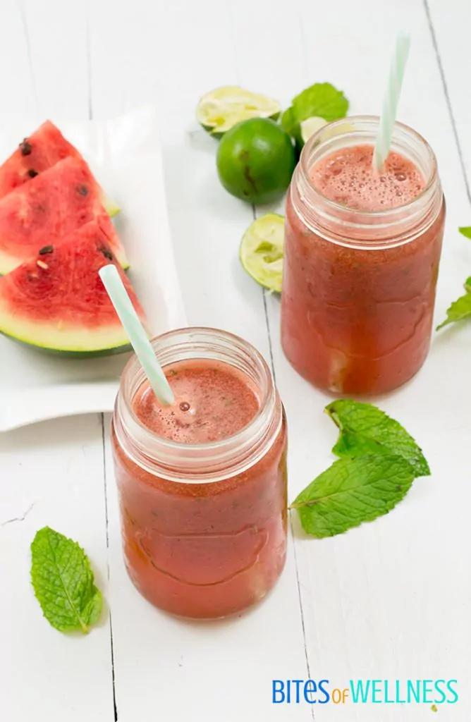 refreshing watermelon mint mocktail in a mason jar with watermelon and limes