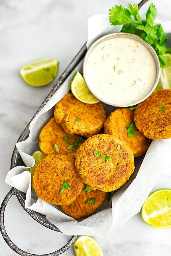 Curry Salmon Cakes in an oval basket with cilantro lime yogurt sauce
