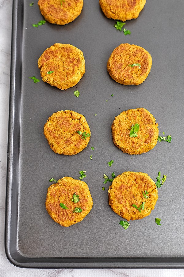 Baking sheet with curry salmon cakes lined up