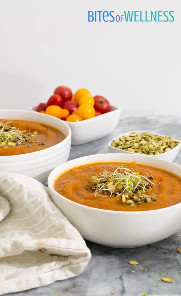 Two bowls of slow cooker curried butternut squash soup with sprouts and pumpkin seeds