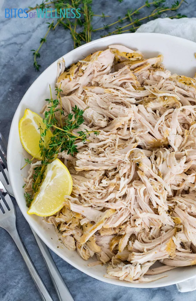Slow cooker shredded chicken recipe on a plate with garnish 