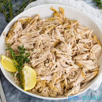 Slow cooker shredded chicken recipe on a plate with garnish