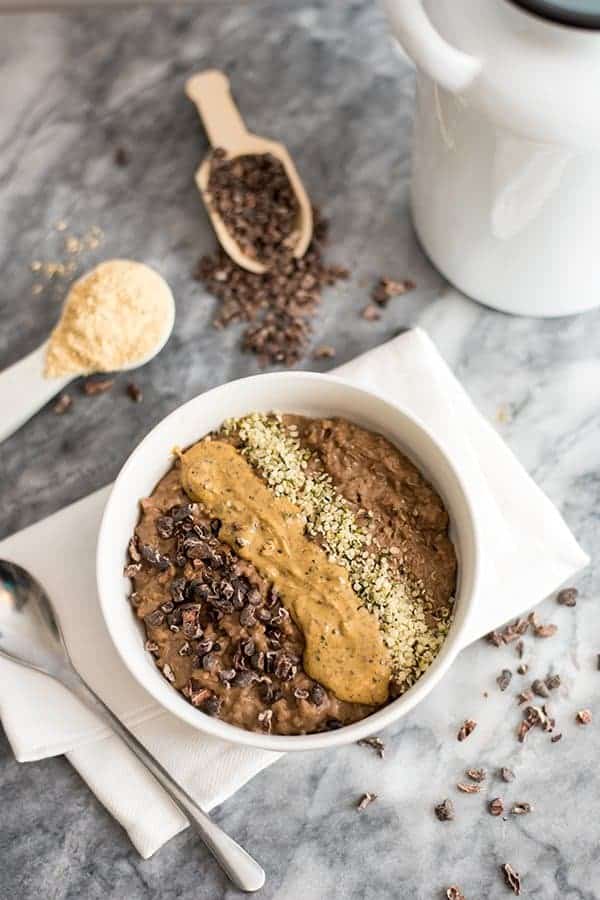 Chocolate Peanut butter Low Carb Oatmeal in a bowl with peanut butter, cocoa nibs and hemp hearts on top