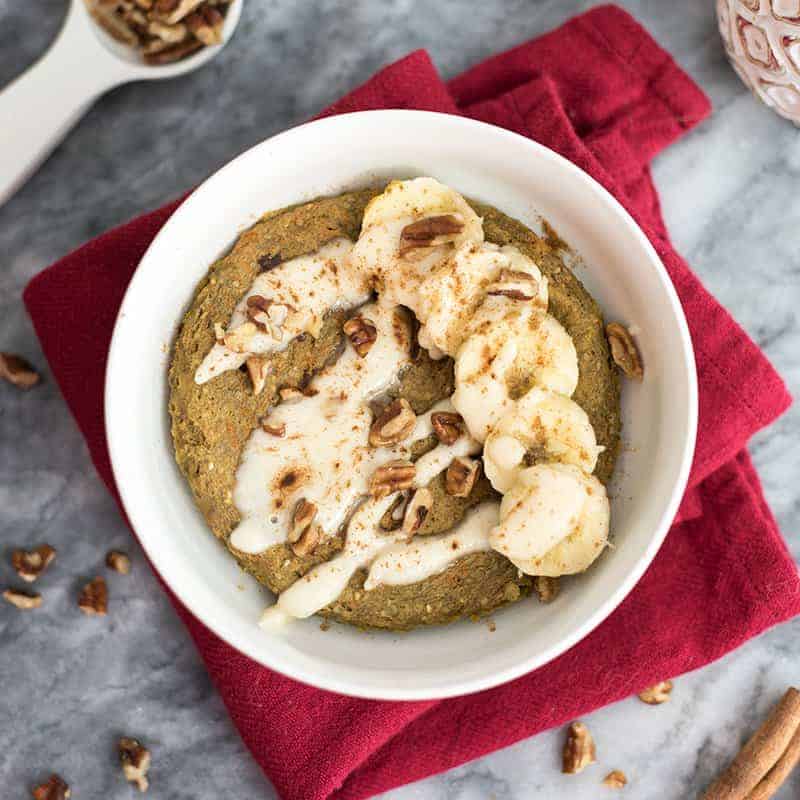 Gingerbread mug cake with cut up banana, nuts and coconut butter drizzle 