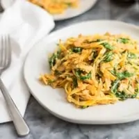 butternut squash noodles with a creamy garlic sauce with arugula on white plate with fork