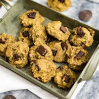 Healthy Oatmeal Chocolate Chip Cookies on a green tray over a white napkin, surrounded by chocolate chunks