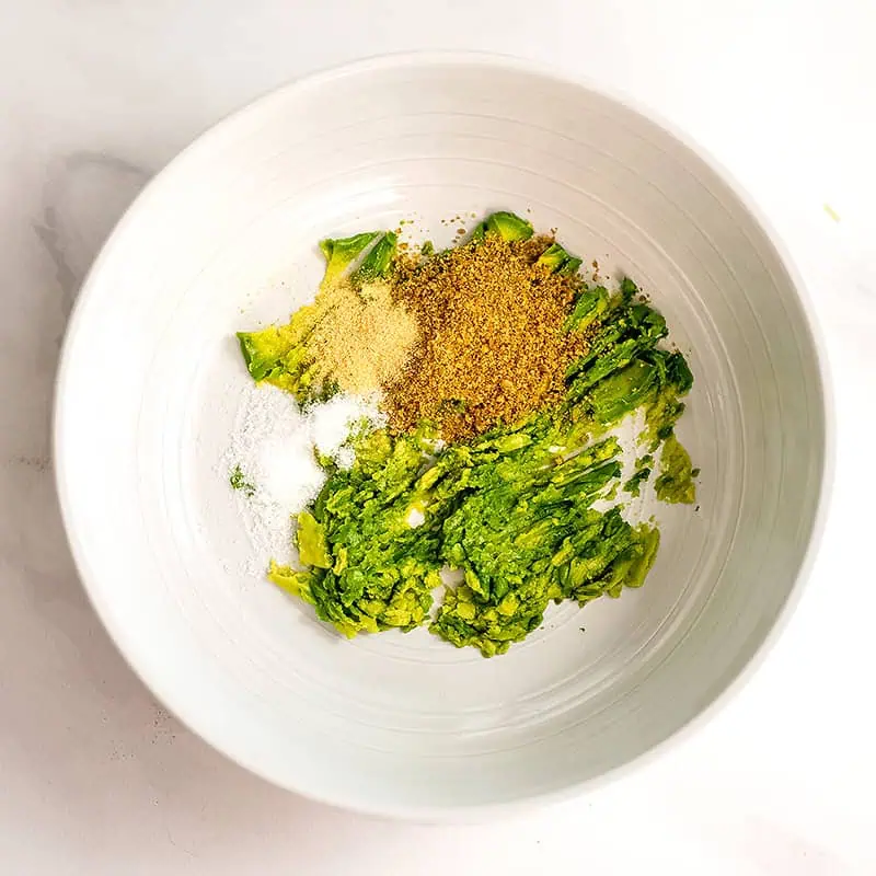 Bowl filled with mashed avocado and spices.
