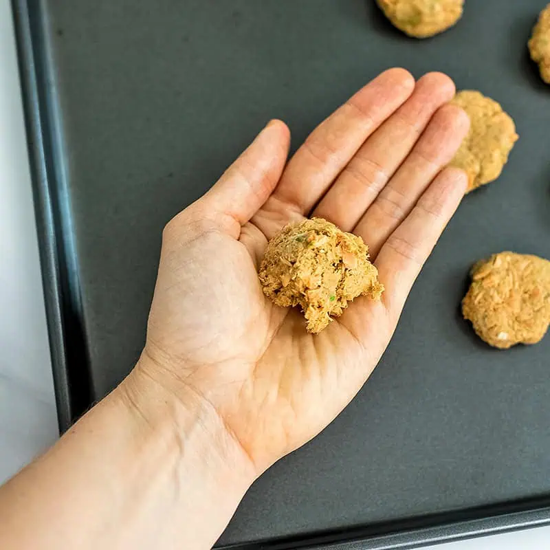 Canned salmon cakes being formed by hand.