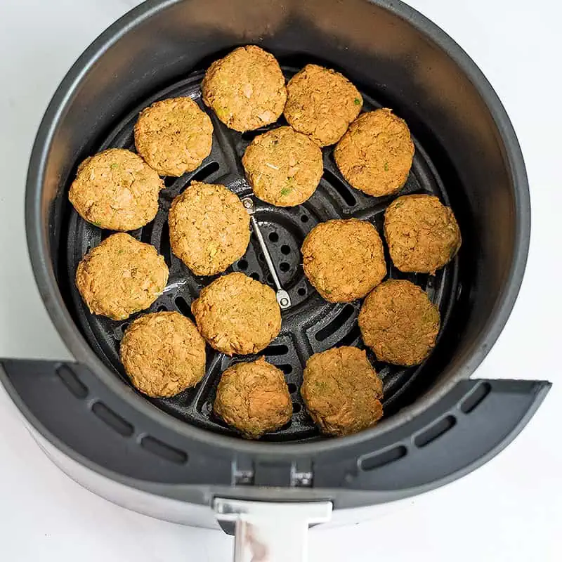 Canned salmon bites in air fryer basket before cooking.