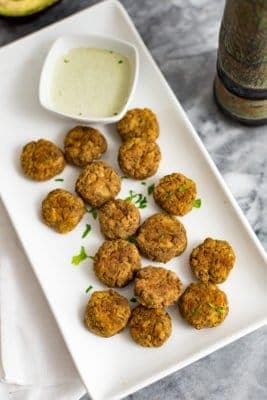 Salmon Bites on a white dish with a white garlic dipping sauce in a white ramekin