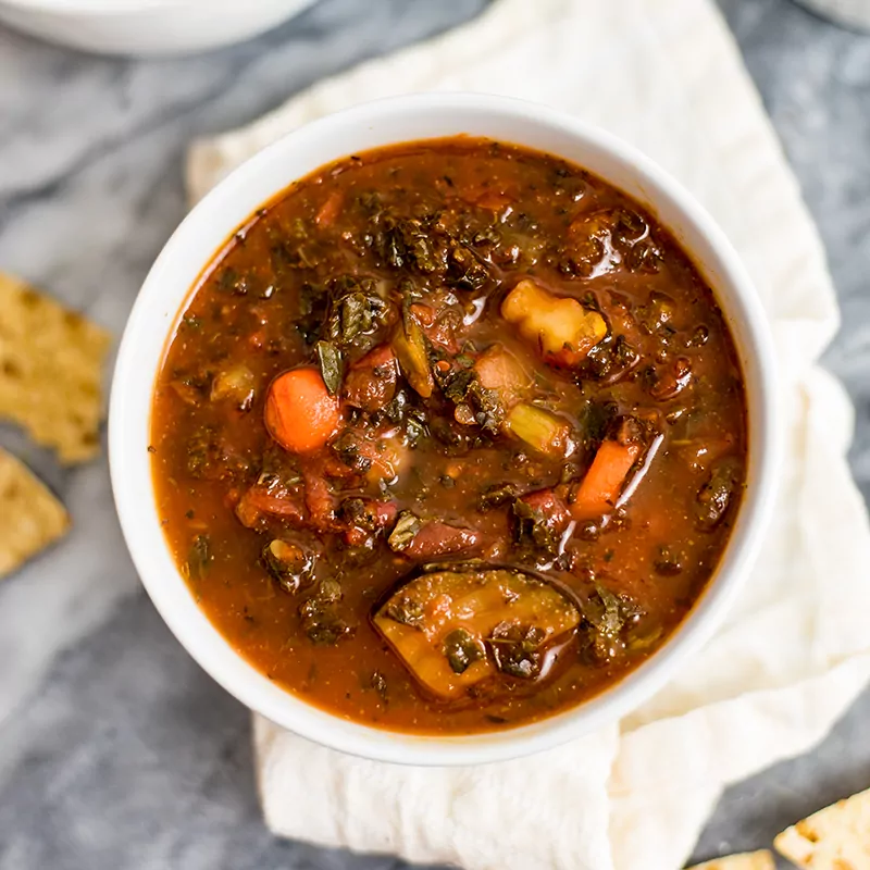 Mediterranean Vegetable Soup in a white bowl on a white napkin