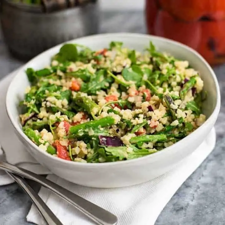 Asparagus Spring salad in a white bowl on white napkin with 2 forks