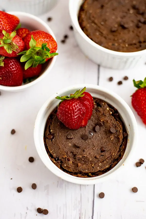 Close up of a single serve brownie in a white ramekin with chocolate chips sprinkled on top 