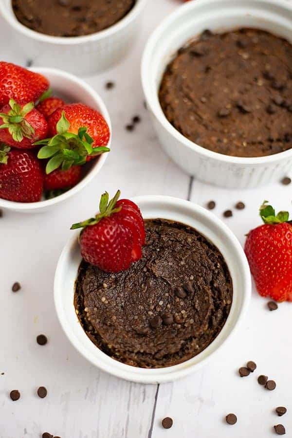 overhead shot of a single serve brownie in a white ramekin with a sliced strawberry on top