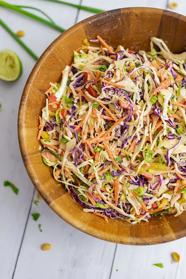 Large wooden salad bowl filled with Asian Cabbage Slaw