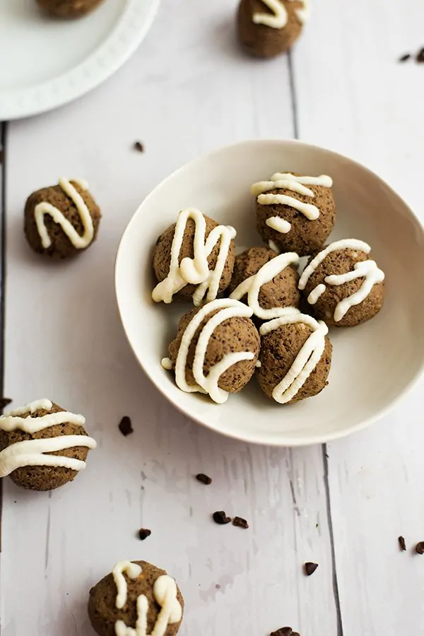 Mocha quinoa energy bites in a white bowl surrounded by more quinoa energy bites