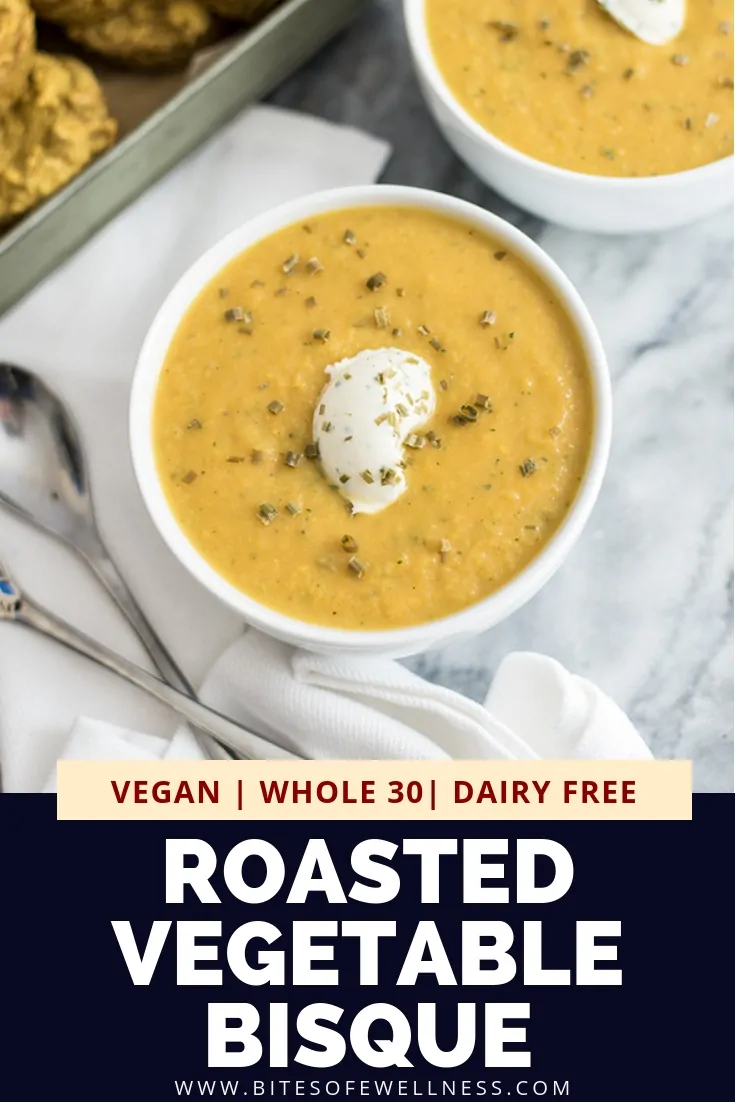 White bowl filled with roasted vegetable bisque on a white napkin with two spoons to the left of the bowl of bisque with pinterest text on the bottom