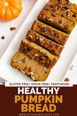 Overhead shot of healthy pumpkin bread recipe cut into slices over a white rectangular plate with pumpkins in the background with pinterest text on the bottom