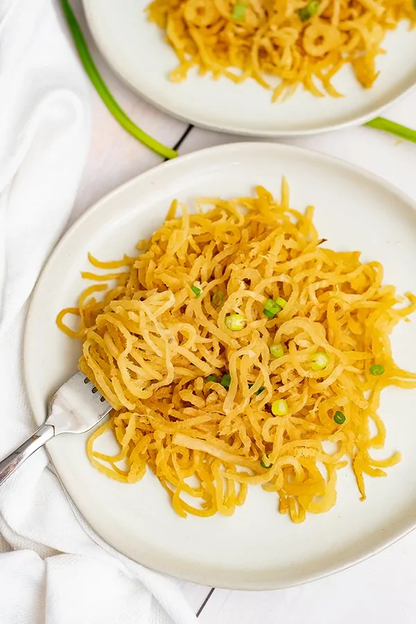 Overhead shot of plate of sesame asian low carb noodles with a fork on the left side of the plate with pasta twirled on the fork.