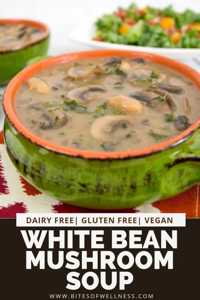 Green bowl filled with best ever white bean mushroom soup with a salad in the background. Pinterest text on the bottom of the photo