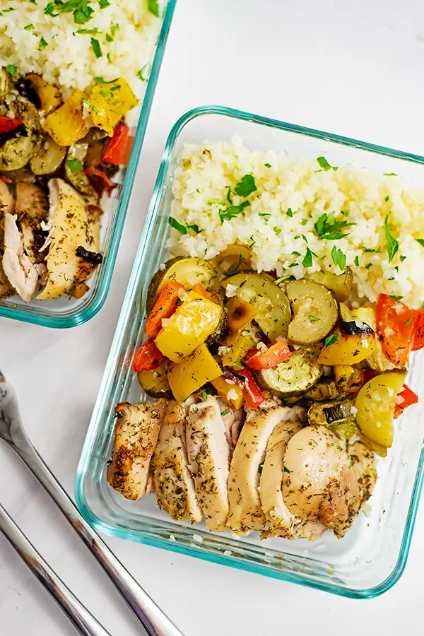 Rectangle shaped pyrex container filled with greek chicken marinade sheet pan dinner and cauliflower rice