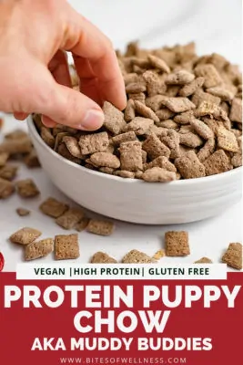 Hand reaching into a bowl of protein puppy chow with pinterest text on the bottom