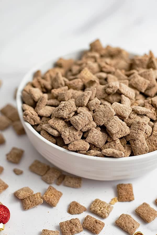 Large white bowl filled with protein puppy chow with holiday ornaments in the foreground