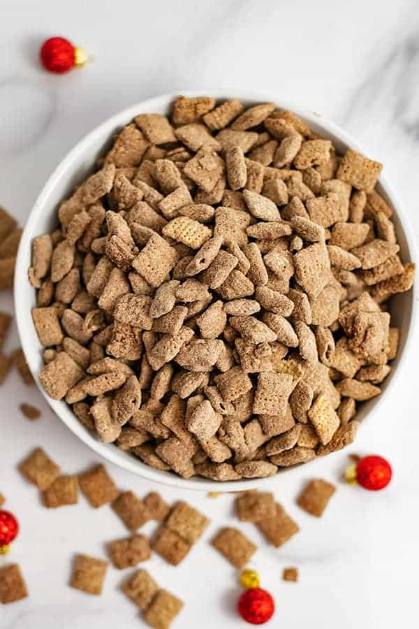 Overhead shot of a bowl of protein puppy chow with holiday ornaments around the bowl