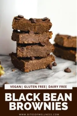 Black bean brownies stacked on top of each other (4 total) with more brownies in the background. pinterest text on the bottom