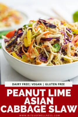 Large white bowl filled with asian cabbage slaw with peanut lime dressing with pinterest text on the bottom of the photo