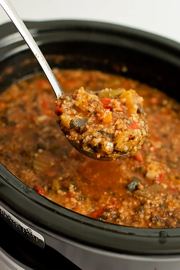 Large ladle full of crockpot low carb vegetable soup