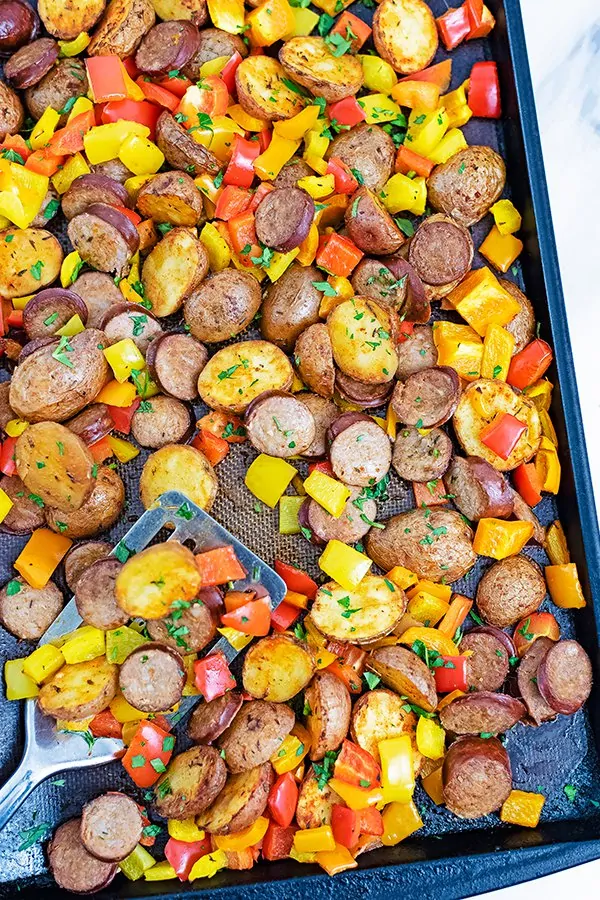 Sheet pan filled with turkey kielbasa, potatoes and bell pepper after cooking