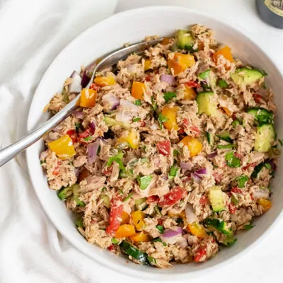 Large bowl filled with healthy Mediterranean tuna salad (no mayo) with a fork resting on the side of the dish