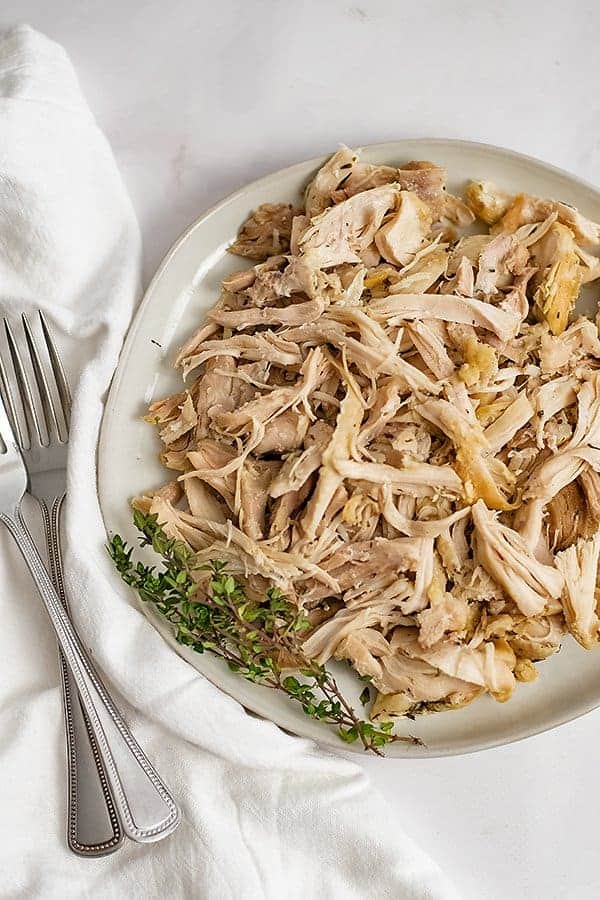 Plate filled with Instant Pot Shredded Chicken with two forks on left