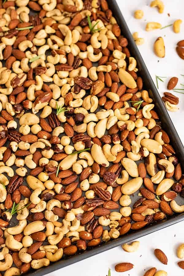 Overhead shot of a baking sheet filled with rosemary savory spiced nuts