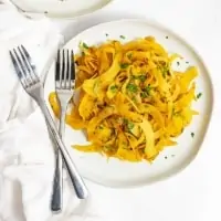 Overhead shot of white plate filled with spiralized rutabaga recipe with two forks on the left side of the plate