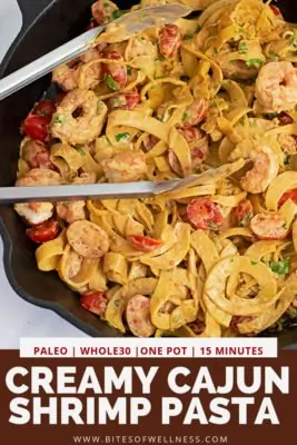 Cast iron skillet filled with Whole30 Creamy Cajun Shrimp Pasta recipe with a pair of silver tongs in the skillet with pinterest text on the bottom of photo