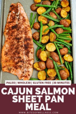 Sheet pan filled with cajun salmon sheet pan meal with an entire salmon fillet, potatoes and green beans. Pinterest text on the bottom of the photo