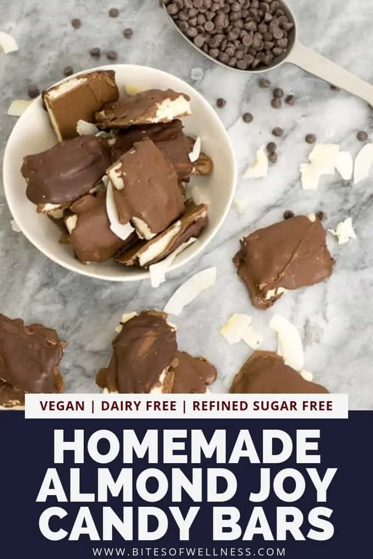 Small white bowl filled with homemade almond joy candy bars surrounded by other candy bars and chocolate chips